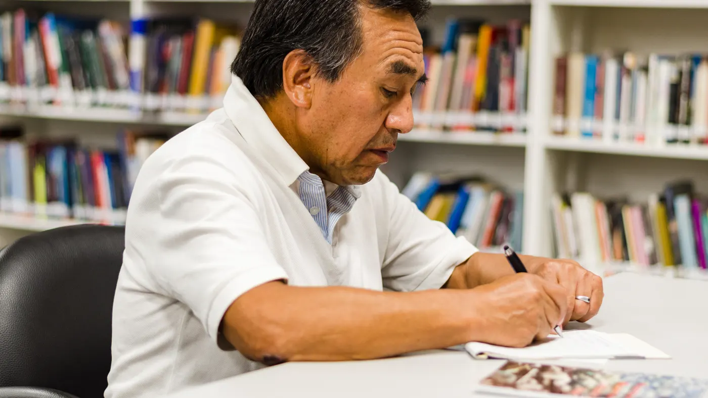 Profesionista documentando su investigación en la mesa de una biblioteca